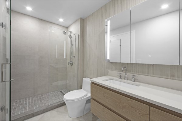 Roosevelt Island Two Bedroom Renovation - Discover the full remodel of a two-bedroom/two-bathroom apartment in New York’s Roosevelt Island by Modern Citi Group. Our goal was to modernize the apartment, enhance aesthetics and functionality, and reflect our clients’ unique tastes.

From meticulous planning, 3D visualizations, architectural drawings, and permitting to flawless execution, the entire project was completed on time and within budget. Collaborating closely with the new homeowners, our dedicated design and construction teams completed kitchen and bathroom remodels, as well as living room, bedroom, and hallway renovations.

Our construction team spared no effort, completing wall and ceiling painting, wood floor installation, baseboard replacement, and intricate electrical work throughout. The kitchen remodel included brand new Luna Dove polished kitchen cabinets, stainless steel appliances, and a stunning peninsula with creamy white waterfall Quartz countertop, adding an exquisite touch of opulence and luminosity to the kitchen design.

During the master bathroom remodel, we reimagined the layout, extended the shower, and bid farewell to the bathtub to create a more spacious and ergonomic space. The addition of a Monterey Oak floating vanity with Carrara marble countertop, complemented by white and beige matte porcelain tile and Kohler fixtures, resulted in a modern yet warm and welcoming bathroom, crowned as our clients' favorite room.

In just twelve weeks, our clients had a fully renovated haven they proudly call home. Ready to embark on your remodeling journey? Contact Modern Citi Group today and let us turn your dream space into a reality!