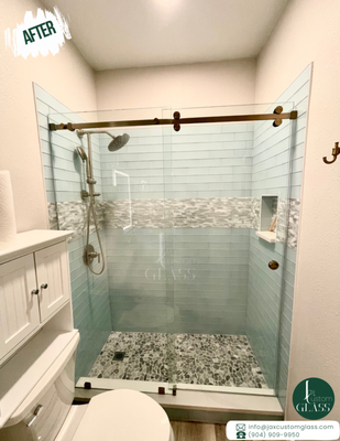 Fixed Panel with one Sliding Glass Door (Brushed Bronze Hardware) - Beautiful Bathroom with outstanding tiles combination that resembles a beach house look. Highlighted by the sophisticated Frameless Shower Enclosure matching the hardware color of the bathroom appliances.