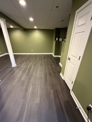 Installing lvp floor - Prepared the basement floor for installation, installed new vinyl flooring throughout the basement, and installed trim around the perimeter for a clean, finished look.