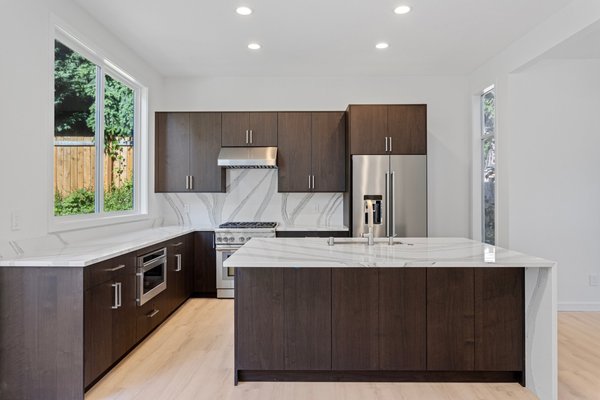 Home Remodel Kirkland - This comprehensive remodel opened up the main living space by removing enclosed kitchen walls, a hallway closet, and dead space. The load-bearing kitchen wall was replaced with a structural beam, and the old fireplace was upgraded to a modern gas model framed in large-format porcelain tile. The main kitchen window sill was raised to match the new countertop height. Modernized plumbing and electrical systems support custom dark cabinetry, quartz countertops with a waterfall-edge island, and integrated stainless steel appliances. Additionally, the project included building new staircases and fully remodeling the bathrooms with custom tile, frameless glass enclosures, high-end fixtures, and updated layouts.
As a general contractor specializing in full home, kitchen, and bathroom remodels, we handle every detail from design to completion. Reach out to us today to discuss your upcoming project! Home Remodel Kirkland - This comprehensive remodel opened up the main living space by removing enclosed kitchen walls, a hallway closet, and dead space. The load-bearing kitchen wall was replaced with a structural beam, and the old fireplace was upgraded to a modern gas model framed in large-format porcelain tile. The main kitchen window sill was raised to match the new countertop height. Modernized plumbing and electrical systems support custom dark cabinetry, quartz countertops with a waterfall-edge island, and integrated stainless steel appliances. Additionally, the project included building new staircases and fully remodeling the bathrooms with custom tile, frameless glass enclosures, high-end fixtures, and updated layouts.
As a general contractor specializing in full home, kitchen, and bathroom remodels, we handle every detail from design to completion. Reach out to us today to discuss your upcoming project!