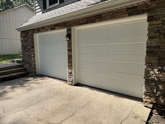 garage door replacement - These were two 20 year old Wayne Dalton doors replaced by two Vintage-200 insulated doors in white long bead board.