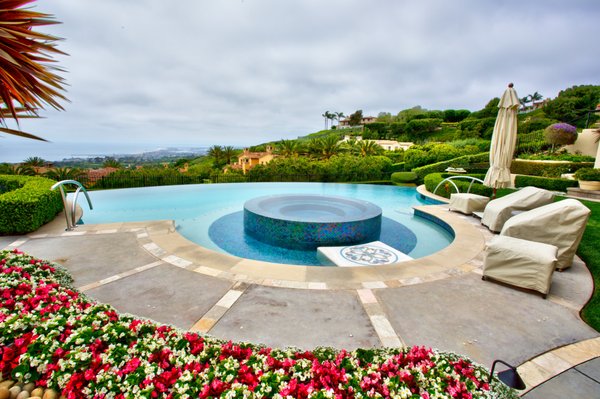 Newport Coast Pelican - Infinity Edge Pool, 360 negative edge spa, iridescent glass tile, smooth marble with reflective glass pool surface, custom Italian mosaic, water spitters, modern artisan series entry rails. Newport Coast Pelican - Infinity Edge Pool, 360 negative edge spa, iridescent glass tile, smooth marble with reflective glass pool surface, custom Italian mosaic, water spitters, modern artisan series entry rails.