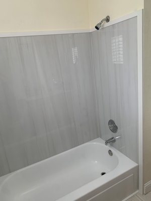 Bathtub Tile Surround Replacement - This Bathtub Tile Surround Replacement is a great example where my expertise in home renovations came through. Originally I had specified a factory made Bathtub Surround but it was a special order item and would take a month to get. That was way too long for my client. After careful measurements, I determined I could remedy the supply problem with an innovative tile design/installation using 4 @ 30" X 60" Rectified Tiles from Spain. PVC Trim was selected to finish the perimeter in order to make a smooth transition to the surrounding walls and base moulding at the same time meeting my requirements to keep it waterproof!