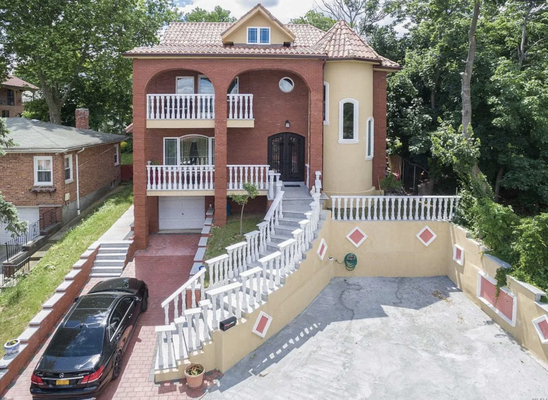 Bayside home remodel - We transformed an original single-story ranch in Bayside into this custom-built, multi-level Mediterranean-style home. The full rebuild features a grand front staircase, stucco and brick façade, decorative balcony railings, a turret-style corner design, and a red tile roof — blending old-world charm with modern structural upgrades.