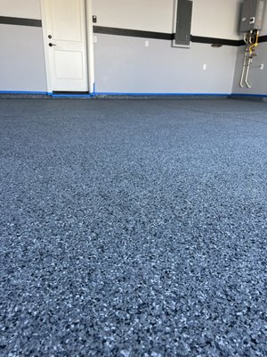 Midnight flake with polyaspartic top coat - This was a 2-day flake system. We started with prepping the concrete by diamond grinding, filling cracks, and then pouring the moisture vapor barrier. After the MVB is installed, we add a full broadcast of flake which is the most durable option. Our last few steps are on day 2 when we scrape the floor to create a consistent texture, then we install the final coat, the highly durable, UV resistant, Polyaspartic. 

We guarantee all of our work with a 10-year adhesion and workmanship warranty.
