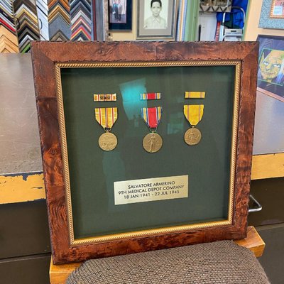 Metal Awards - This display of medals awarded to a medic in WWII is a perfect way to memorialize the hard work and sacrifice that this person gave nearly 80 years ago, and to ensure that his memory is preserved for years to come. The frame is a burl wood molding, with gold painted fillet, fabric mat, and Optium museum acrylic. Metal Awards - This display of medals awarded to a medic in WWII is a perfect way to memorialize the hard work and sacrifice that this person gave nearly 80 years ago, and to ensure that his memory is preserved for years to come. The frame is a burl wood molding, with gold painted fillet, fabric mat, and Optium museum acrylic.