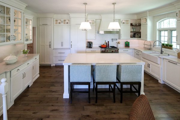 White Kitchen with Gray Quartz Countertops, Farmhouse Sink and Hardwood Floors - This kitchen was 24 years old with the cabinets and appliances not functioning well, the flooring was cracked and in bad shape and the kitchen needed a facelift. Audrey & Karl Schmitt chose Cabinet-S-Top because we are one-stop shop and could remodel everything from floor to ceiling. This white kitchen is a timeless beauty with a style that endures and has many design features to highlight; but the customer loves the way we separated the refrigerator and freezer with a beautiful pantry to give it a more furniture feel. Audrey and Karl praised their designer, Betty Nairn and said she is beyond awesome and is professional, creative, and easy to talk to! White Kitchen with Gray Quartz Countertops, Farmhouse Sink and Hardwood Floors - This kitchen was 24 years old with the cabinets and appliances not functioning well, the flooring was cracked and in bad shape and the kitchen needed a facelift. Audrey & Karl Schmitt chose Cabinet-S-Top because we are one-stop shop and could remodel everything from floor to ceiling. This white kitchen is a timeless beauty with a style that endures and has many design features to highlight; but the customer loves the way we separated the refrigerator and freezer with a beautiful pantry to give it a more furniture feel. Audrey and Karl praised their designer, Betty Nairn and said she is beyond awesome and is professional, creative, and easy to talk to!