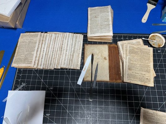 German Bible Repair - This bible was severely water-damaged and needed to be completely disassembled.  The pages were ironed to smooth out the wrinkles, and then they were resewn.  The bible was rebound in leather with gold titles and decorations.