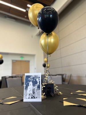 Memorial Event - For this Roman-themed memorial, we brought elegance and sophistication to life with a striking gold and black color scheme. The event featured custom balloon centerpieces, bespoke floral arrangements with vibrant yellow wildflowers, and a beautifully designed memorial table, all thoughtfully crafted to honor and celebrate a loved one.

We specialize in bringing unique visions to life with fully customized designs tailored to any theme or occasion. If you’re looking for something truly special, we’d love to create it for you. Contact us to start planning your custom event!
