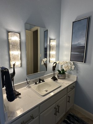 Powder Bath Remodel - Mini-makeover of a powder bath--we kept the floors and vanity and painted the vanity cabinets. We added a new sink, faucet, lighting and paint. In the blue and orange tiled bathroom, we captured the Denver Broncos theme with coordinated wallpaper and accessories.