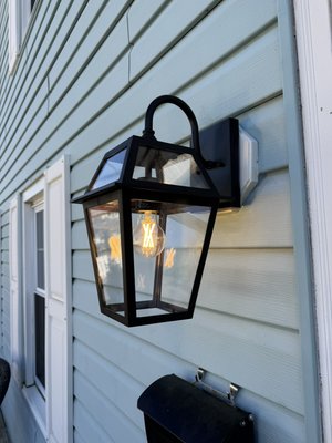 Outdoor lights installation - Installing an outdoor lanterns and caulking around with silicone to protect against the rain or snow Outdoor lights installation - Installing an outdoor lanterns and caulking around with silicone to protect against the rain or snow