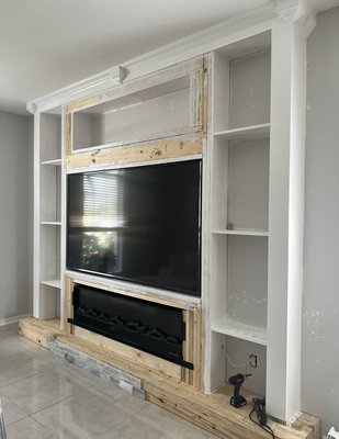 Custom built in entertainment center - We did this custom entertainment center. From framing it out painting it, installing the stone tile, custom shelving, marble boarders and crown molding’s!