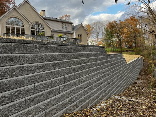 Retaining wall - Huge retaining wall to raise this customers back yard. 70000 tons of material and backfill. Another happy customer. Retaining wall - Huge retaining wall to raise this customers back yard. 70000 tons of material and backfill. Another happy customer.