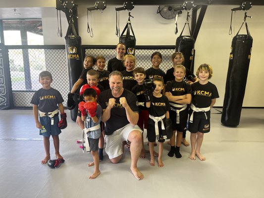 Kids Martial Arts - Kids Martial Arts at Kombative Concepts Martial Arts – Anthem, AZ

At Kombative Concepts Martial Arts (KCMA), our Kids Martial Arts Program is about so much more than kicks and punches. We believe martial arts should build confidence, discipline, focus, and respect – the life skills kids need to succeed both on and off the mats.

Our structured program blends age-appropriate martial arts training with positive coaching and character development. Students learn real self-defense skills while developing the focus, perseverance, and self-control that carry over into school, home, and everyday life.

What Makes Our Kids Program Different?

Age-Specific Training – Classes are divided by age and skill level so every child can learn at the right pace.

Progressive Curriculum – From fundamental stances and striking to balance, coordination, and teamwork drills, kids follow a clear path of achievement.

Character Development – Respect, focus, listening skills, and perseverance are emphasized in every class. Parents see improved behavior, better focus in school, and greater self-confidence.

Safe & Supportive Environment – Our academy is welcoming, encouraging, and structured. Kids learn to work hard, but also to support and encourage their teammates.

Real Martial Arts Skills – With instruction rooted in Kickboxing, Boxing, Brazilian Jiu Jitsu, and Jeet Kune Do, your child will learn effective, practical techniques that build both physical skill and mental toughness.