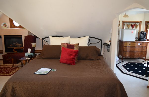 The Turret Suite features a tuscan decor - Discover an elegant mood in this full floor Tuscan theme suite. Your ultimate comfort is our goal for your stay.

Experience an open and airy feeling under the vaulted ceiling which has been hand painted as a peaceful sky. Relax in the two person Ultra Ban whirlpool or the two comfortable stuffed chairs beside the gas fireplace. A small deck balcony is attached to this suite. Breakfast for two is available in the window turret with private coffee bar, which also overlooks the historic neighborhood. 

Need to accommodate more guests, reserve the attached second bedroom with a full bed. The living room has a queen futon (couch/sleeper) and a 32″ smart TV with pre-loaded cable channels. This elegant full floor space has been designed for two people to enjoy. If you have a larger group, this suite can comfortably sleep 7 – we will set-up for extra guests with the add-on rate below.