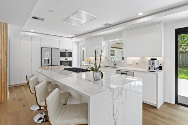 Refined Modern Living - The client approached us seeking a complete remodel for their space. The building presented numerous challenges, including low ceilings and unchangeable window placements. Despite these limitations, we crafted a ceiling design to optimize perceived height and strategically added skylights to bring natural light into the master bathroom. The client envisioned a warm, welcoming atmosphere with modern simplicity, all within a reasonable budget. Our scope was focused solely on the architectural layout and finishes; furnishings and decor were selected independently by the client.