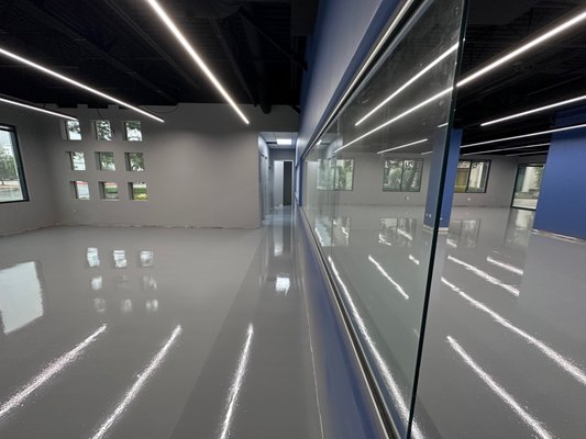 Epoxy Floor Commercial Space - We undertook a transformative project for our valued client, completely revamping their commercial space. The space originally featured a combination of carpet and vinyl tiles, which no longer met the client's specific requirements. We replaced these with a stunning epoxy and urethane matte finish, meticulously crafted to align with the client's vision and intended use of the area.
At our core, we take immense pride in our work, adhering to the highest standards of detail and professionalism at every stage of the project. Our mission is to provide tailored flooring solutions that perfectly align with the unique needs of our clients. Whether it's a commercial space, office, or any other environment, we're committed to delivering top-notch results that exceed expectations. Your satisfaction is our ultimate goal, and we're dedicated to transforming spaces to better suit your specific needs. Epoxy Floor Commercial Space - We undertook a transformative project for our valued client, completely revamping their commercial space. The space originally featured a combination of carpet and vinyl tiles, which no longer met the client's specific requirements. We replaced these with a stunning epoxy and urethane matte finish, meticulously crafted to align with the client's vision and intended use of the area.
At our core, we take immense pride in our work, adhering to the highest standards of detail and professionalism at every stage of the project. Our mission is to provide tailored flooring solutions that perfectly align with the unique needs of our clients. Whether it's a commercial space, office, or any other environment, we're committed to delivering top-notch results that exceed expectations. Your satisfaction is our ultimate goal, and we're dedicated to transforming spaces to better suit your specific needs.
