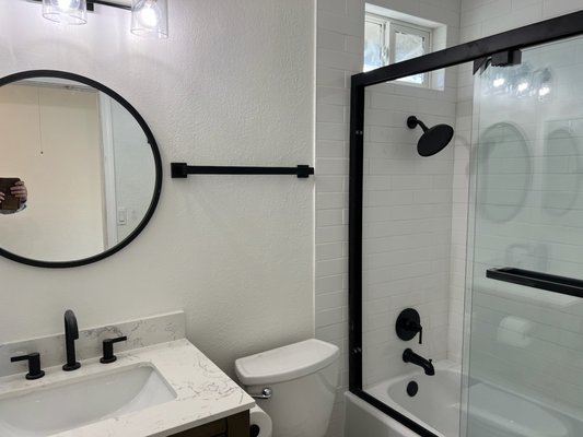 Modern Bathroom Remodel - This hall bathroom remodel was started to refurbish an out of date and damaged bathroom from a rental property. The bathroom was taken down entirely and made new with custom shower tiling, new vanity, mirror and lighting, as well as new floors.