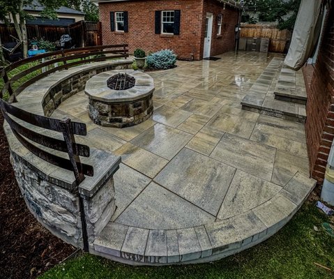 Paver Project Denver Co - Paver patios offer a durable, customizable outdoor space that avoids the cracking issues of concrete. The firepit, surrounded by a sitting wall, creates an inviting and safe gathering spot. Together, they enhance property value with aesthetic appeal and practical drainage benefits.