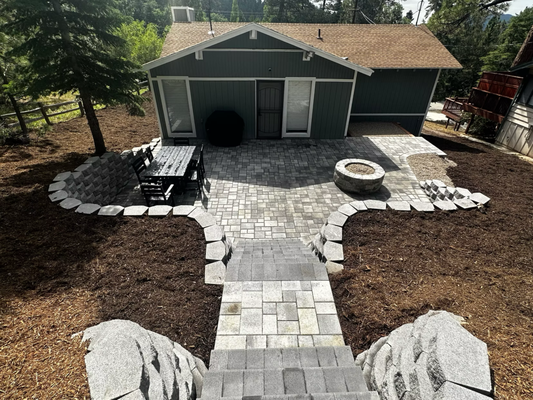 Backyard custom design - We transformed this outdoor space by completing full excavation and grading, building a durable block retaining wall, and installing a beautiful paver patio with a cozy fire pit. To finish the design, we added a block stairway that provides easy access to the kids’ playground.