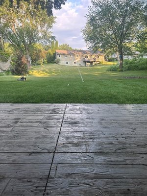 Stamped and Dyed Concrete Patio - This backyard job included removal of an old patio and railroad tile gardens. Dirt was brought in and the backyard leveled then prepped for a 27ft by 14ft patio with dyed concrete that was stamped. It turned out beautiful.