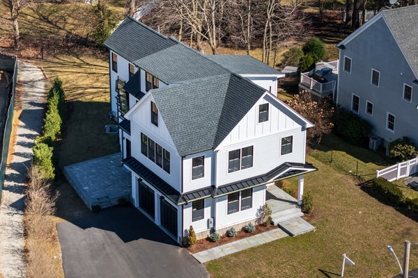 Modern Farmhouse New Home Build in Wellesley, MA - MassTech Roofing helped an area investor build this brand new home in Wellesley recently listed on the market.
After the old home was demolished by the investor, MassTech was brought in to do all of the exterior work starting with framing the entire home.
Following the plans from the investor’s architect, we installed Hardie board siding in a modern farmhouse style along with black Anderson windows.
For the roofing, we used investor-supply GAF shingles and installed aluminum, standing seam metal roofing accents along with black gutters. To complete the modern farmhouse look, we also installed PVC board and batten which is designed to last for decades to come with virtually no maintenance (just power washing). Modern Farmhouse New Home Build in Wellesley, MA - MassTech Roofing helped an area investor build this brand new home in Wellesley recently listed on the market.
After the old home was demolished by the investor, MassTech was brought in to do all of the exterior work starting with framing the entire home.
Following the plans from the investor’s architect, we installed Hardie board siding in a modern farmhouse style along with black Anderson windows.
For the roofing, we used investor-supply GAF shingles and installed aluminum, standing seam metal roofing accents along with black gutters. To complete the modern farmhouse look, we also installed PVC board and batten which is designed to last for decades to come with virtually no maintenance (just power washing).