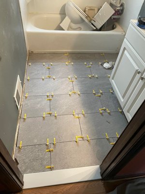 Half Bathroom - In this project the home owner just wanted to install some new tile in the entrance of the bathroom this is how it came out .