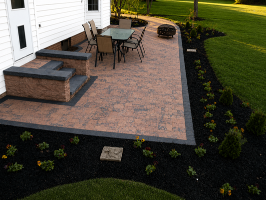 Custom Backyard Paver Patio & Landscape Installation - This backyard transformation features a custom paver patio designed for comfortable outdoor living and entertaining. The project included a decorative paver layout with contrasting borders, integrated planting beds with fresh mulch, colorful seasonal flowers, evergreen shrubs, and a seamless connection to the existing concrete walkway. The finished design provides a durable, low-maintenance outdoor space while enhancing the home's beauty, functionality, and curb appeal. Custom Backyard Paver Patio & Landscape Installation - This backyard transformation features a custom paver patio designed for comfortable outdoor living and entertaining. The project included a decorative paver layout with contrasting borders, integrated planting beds with fresh mulch, colorful seasonal flowers, evergreen shrubs, and a seamless connection to the existing concrete walkway. The finished design provides a durable, low-maintenance outdoor space while enhancing the home's beauty, functionality, and curb appeal.
