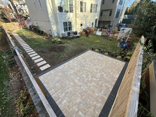paver patio and landscaping in the backyard - It was a backyard where there was only dead grass. The client opted for a 14x18 square foot paver patio and a planting bed where we planted different types of perennial plants and installed stepping stones towards the steps of the side deck of the house