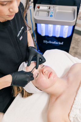 The Deluxe Dermaplane Facial - The Deluxe Dermaplane Facial offers an advanced exfoliation treatment that removes dead skin cells and vellus hair, revealing a smoother, brighter complexion. This luxurious facial also includes a nourishing mask, customized serums to enhance hydration and promote skin health, and cooling ice globes to soothe the skin.