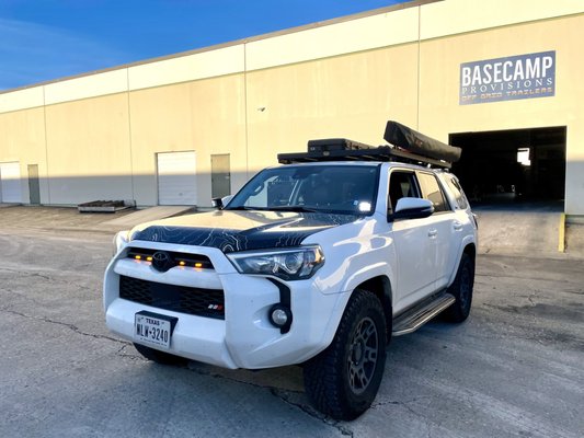 Off-Road Auxiliary Lighting Upgrade: Elevating the 2020 4Runner with Ditch, Side, and Chase Lights Installations - We take pride in sharing the details of a recent installation job that transformed a 2020 4Runner into the ultimate off-road machine. Our team at Basecamp Provisions spared no effort in enhancing both form and function with an array of premium upgrades.

Ditch Light Mastery:
Witness the power of Cali Raised LED ditch lights paired with sleek low-profile brackets. We've seamlessly integrated these high-performance lights to illuminate the darkest trails, providing enhanced visibility for a safer and more adventurous off-road experience.

Rear Chase Lights Brilliance:
Immerse yourself in the mesmerizing glow of Baja S2 Sport rear chase lights. Our expert installation ensures not only a striking visual appeal but also an additional layer of safety during night-time off-roading. Elevate your 4Runner's aesthetic while making a bold statement on the trails.

Auxbeam Switch Controller Expertise:
Experience convenience at your fingertips with the Auxbeam Switch Controller. Our meticulous installation guarantees easy control of various lighting components, giving you the power to customize your 4Runner's lighting setup effortlessly. Convenience meets functionality for the ultimate off-road journey.

MAXTRAX Dominance & Mounting Mastery:
Explore new terrains confidently with MAXTRAX recovery boards securely mounted on our custom brackets. Our team has expertly designed and installed the mounting system, ensuring quick and easy access to these essential off-road tools. Conquer challenging landscapes with the assurance that your MAXTRAX is always within reach.

At Basecamp Provisions, we take pride in our commitment to excellence and precision. Our passion for enhancing off-road experiences shines through in every installation, ensuring that your vehicle is not just a vehicle but a true reflection of your adventurous spirit. Trust us to elevate your off-road journey to new heights. Explore the trails with confidence, knowing that your vehicle is equipped with the best-in-class upgrades.
