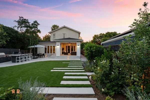 The Willow Project | Front & Backyard Remodel - The Willow Project in Willow Glen is a stunning transformation that proves simplicity and luxurious outdoor living can seamlessly coexist. Designed with both beauty and functionality in mind, this backyard features a custom outdoor kitchen, serene landscaping, and elegant designer lighting throughout. A covered pergola with motorized shades creates a comfortable, enclosed space that feels like a natural extension of the home, while a custom fire pit provides the perfect setting for relaxing evenings and effortless entertaining.