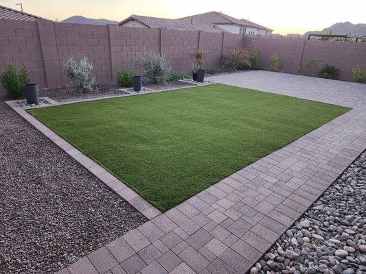 New travertine walkway with cactus garden. - Desert Vine Landscaping recently completed a stunning backyard transformation featuring a new travertine walkway surrounded by desert-friendly landscaping. The design features a lush artificial turf centerpiece surrounded by decorative rock, accent planters, and a custom cactus garden, blending modern elegance with low-maintenance beauty. This project showcases Desert Vine’s expertise in designing clean, functional outdoor spaces that are ideally suited for Arizona's unique living environment. New travertine walkway with cactus garden. - Desert Vine Landscaping recently completed a stunning backyard transformation featuring a new travertine walkway surrounded by desert-friendly landscaping. The design features a lush artificial turf centerpiece surrounded by decorative rock, accent planters, and a custom cactus garden, blending modern elegance with low-maintenance beauty. This project showcases Desert Vine’s expertise in designing clean, functional outdoor spaces that are ideally suited for Arizona's unique living environment.