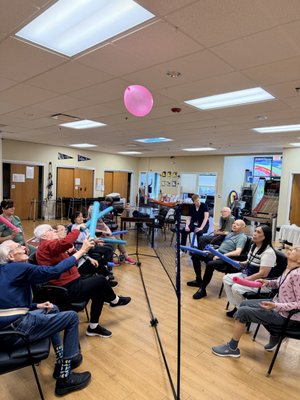 A day at our Senior Center - Your loved one arrives in the morning and is greeted by name. From there, the day has a shape to it — structure, company, and people paying attention. That is the difference between being cared for and simply being watched.

We are open weekdays, 7:30 AM to 5:30 PM. Come for the full day or part of it. Two days a week is our minimum, and the days are flexible from week to week.

A Day Here

Morning — arrival and check-in

Members are welcomed in, settled with breakfast, and seen by our nursing team. A registered nurse takes vitals and notes anything that has changed since the last visit. Medications are given on schedule. It is a quiet start, on purpose — mornings can be disorienting, and we let people arrive at their own pace.
Late morning — moving and thinking

This is the most active stretch of the day. Group exercise and chair yoga, stretching, NuStep and pedal bikes, laps on the walking track. Then the thinking games: trivia, word games, cards, bingo, puzzles. We match the challenge to the person, so everyone finishes something.
Midday — lunch together

A hot lunch, served at tables, with conversation. For many members this is the only meal of the day they do not eat alone. Our nutrition consultant reviews individual needs, and alternative options are available for dietary restrictions and personal preferences.
Afternoon — art, music, and connection

Art projects, singing, pet therapy, dancing, and time on the patio when the weather is good. Afternoons are when personality comes back out. Families often tell us their loved one is more talkative at dinner on the days they have been with us.
Late afternoon — winding down

As the light changes, we shift deliberately: softer music, calmer activities, smaller groups. Sundowning is real, and we plan the last part of the day around it rather than letting it take us by surprise. Members go home settled instead of agitated.

Nursing and Health Support

Our registered nurses monitor six vital signs every day and build a personalized care plan for every member. They manage medication distribution, watch skin integrity, and catch changes early — the kind of small shifts that are easy to miss at home and expensive to miss entirely.

Our CNAs provide hands-on support throughout the day with mobility, toileting, feeding, and personal care — always with dignity and patience. All of our professional staff are certified in CPR and First Aid.

Some members come to us after a hospital or rehab discharge. Some need post-hospital care or IV therapy. We can talk through what your family member needs.
Memory Care Programming

For members living with dementia or memory changes, our programming is built specifically for them — not adapted from something else at the last minute.

    Cognitive games and trivia scaled so every member can participate and succeed
    Art therapy that does not depend on memory or fine motor precision
    Music therapy in the late afternoon, timed to the sundowning hours
    Large-format materials and simple instructions across every activity
    A predictable daily rhythm, because routine itself is a form of care

We serve adults living with Alzheimer’s, dementia, Parkinson’s, and other cognitive or physical challenges, alongside members who simply need company, supervision, and a reason to get out of the house.
Therapy, Right Here

Physical and occupational therapy consultants work onsite. That means no separate appointment, no second trip across town, no arranging another ride. Therapy happens as part of the day your loved one is already having.
Getting Here

Transportation to and from the center can be arranged, with a handicap-accessible bus serving a 20-mile radius. Members come to us from more than 19 communities across the west suburbs — Naperville, Lisle, Aurora, Downers Grove, Bolingbrook, Plainfield, Wheaton, Hinsdale, and beyond.
No Two Days Are the Same

Our activity calendar changes monthly. Members are encouraged to try things they have never done and to keep doing the things they have always loved. See what is happening this month on our calendar.
Come See a Day for Yourself

The best way to know whether this is right for your family is to walk in and watch an ordinary Tuesday. Schedule a tour and see it in progress.

 Leading long-term care insurance providers cover our adult day healthcare services. Contact your carrier to confirm your coverage.
