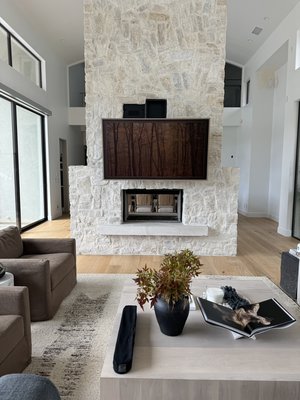 Motorized Mantle Mount on Stone Fireplace - Our team worked closely with the general contractor and design team to plan and execute this custom fireplace install on a stone fireplace. Motorized Mantle Mount allows for tv height to be remotely adjusted for the perfect viewing angle!
