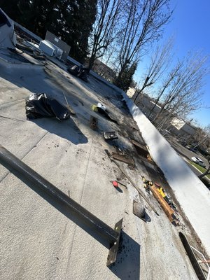 Commercial drain repair - Commercial roof leak repair completed at a faulty drain. Cleaned the drain area and replaced damaged sections with new decking and a properly installed drain. Installed a nail-down base sheet for stability, followed by a torch-down cap sheet for waterproofing. Finished with granule application to match the existing roof for a seamless look.
