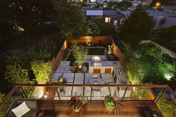 SF Backyard Transformed - Part of another full home remodel, this typical rectangular San Francisco backyard was transformed into an inviting and usable, multi-level outdoor living space.
New roof decks connect to the top floor living area and middle floor primary bedroom, adding valuable space to each level. Minimal steel cable railings avoid obstructing the views. At ground level, expansive double french doors open onto a custom concrete paver and Ipe wood patio. A generous L-shaped outdoor kitchen island frames the patio area and allows for ample storage and prep space. A few steps down lead to a lounging area, featuring drought-friendly and maintenance-free artificial grass as well as a cozy, custom-built natural gas fire pit surrounded by a Redwood bench. Redwood fencing, low-voltage LED landscape lighting, drip irrigation, planting and a water feature completed the space. SF Backyard Transformed - Part of another full home remodel, this typical rectangular San Francisco backyard was transformed into an inviting and usable, multi-level outdoor living space.
New roof decks connect to the top floor living area and middle floor primary bedroom, adding valuable space to each level. Minimal steel cable railings avoid obstructing the views. At ground level, expansive double french doors open onto a custom concrete paver and Ipe wood patio. A generous L-shaped outdoor kitchen island frames the patio area and allows for ample storage and prep space. A few steps down lead to a lounging area, featuring drought-friendly and maintenance-free artificial grass as well as a cozy, custom-built natural gas fire pit surrounded by a Redwood bench. Redwood fencing, low-voltage LED landscape lighting, drip irrigation, planting and a water feature completed the space.