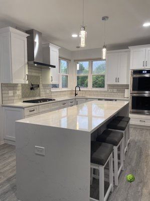 Modern Kitchen with Pot Filler - Cabinet Tree Studio Remodel

Project Details:
• Kith Cabinets 
• Wood Type: Solid Maple 
• Perimeter Finish: Bright White 
• Island Finish: Willow 
• Door style: Homestead II 
• Quartz Tops: Mysterio by Vicostone 
• Floor: New Standard II Aruba by Triumph 
• Jenn-Air Stainless Steel Gas Cooktop: JGC3536GS 
• Jenn-Air Pyramid Style Canopy Wall Hood: JXW8536DS 
• Stainless Steel Double Wall Oven: JJW2830DS
