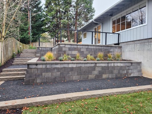 Back Yard Outdoor Living Project - The back yard was not very functional as the wood deck cut off access to most of the yard. We designed and implemented a complete remodel of the space to accommodate outdoor living. This included a series of retaining walls, steps, a paving stone patio with a stainless steel cable railing, irrigation, planting, and landscape lighting. Back Yard Outdoor Living Project - The back yard was not very functional as the wood deck cut off access to most of the yard. We designed and implemented a complete remodel of the space to accommodate outdoor living. This included a series of retaining walls, steps, a paving stone patio with a stainless steel cable railing, irrigation, planting, and landscape lighting.