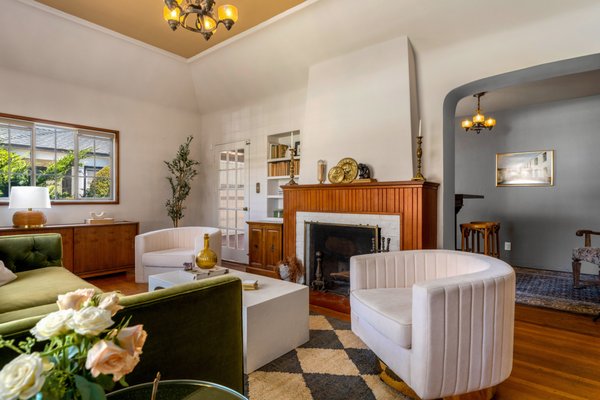 Old Charm - This charming kitchen renovation in Glendale, California, blends vintage character with modern functionality. Featuring sage green cabinetry, unlacquered brass hardware, and honed marble countertops, the space honors the home’s original character while offering a fresh perspective on classic design. The checkerboard hardwood floors, café curtains, and antique-style range bring timeless warmth, while custom millwork and hidden appliances keep things clean and functional. From the decorative open shelving to the floral-accented powder room nearby, every detail was designed with artistry and intention.