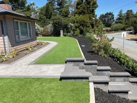 Front Yard Landscape Design and Build Featuring Retaining Walls - This project is a full-scale landscape design and build, featuring a paver walkway, outdoor steps, and retaining walls. The design also incorporates landscaping with plants, outdoor lighting, and artificial grass for a low-maintenance yard. Completed in Hillsborough, CA (94010). Front Yard Landscape Design and Build Featuring Retaining Walls - This project is a full-scale landscape design and build, featuring a paver walkway, outdoor steps, and retaining walls. The design also incorporates landscaping with plants, outdoor lighting, and artificial grass for a low-maintenance yard. Completed in Hillsborough, CA (94010).