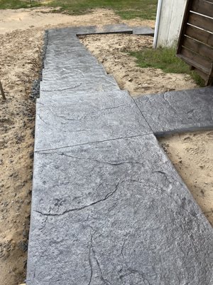 Stamped concrete stair-set & patio (new house) - This was a new “Seamless Slate” -style stamped concrete stair-set, starting from the adjacent driveway, leading down to a connected stamped concrete patio area.