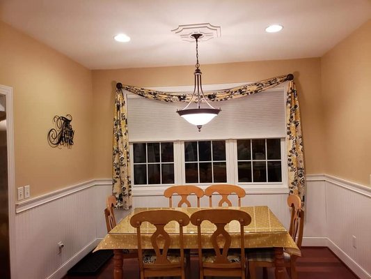 Breakfast Nook Transformation - This breakfast nook area was updated by changing the blinds, adding beadboard and chair railing, new paint, light fixture, and new curtain sashes.