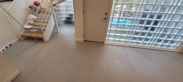 Livingroom Floor - Livingroom floor: 12x36" porcelain tile installation and grout installation with a special cut around the curved glass brick wall and stairs. Electrical heating was also installed before the tiles. Livingroom Floor - Livingroom floor: 12x36" porcelain tile installation and grout installation with a special cut around the curved glass brick wall and stairs. Electrical heating was also installed before the tiles.