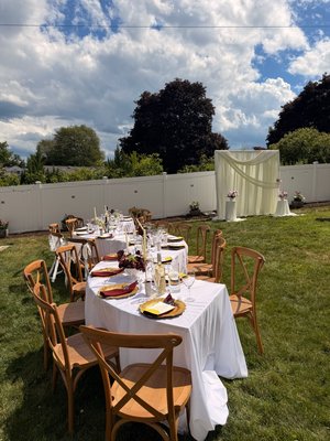 Garden Bridal Shower - A lovely backyard bridal shower featuring cross-back chairs, white linens, soft candlelight, and a romantic backdrop for an intimate celebration. Garden Bridal Shower - A lovely backyard bridal shower featuring cross-back chairs, white linens, soft candlelight, and a romantic backdrop for an intimate celebration.
