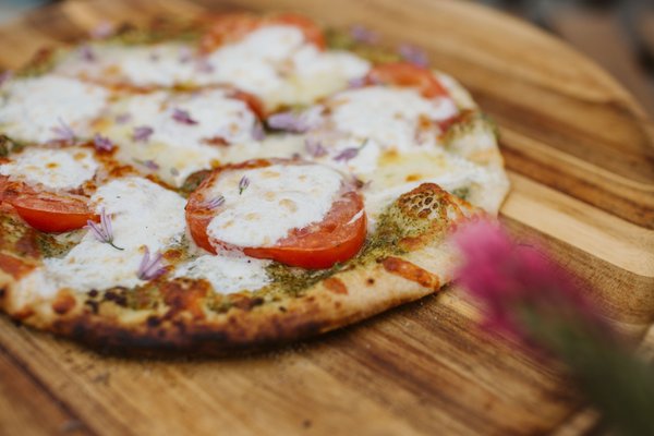 Wood Fire Pizza Pop-Up - We love to do wood fire pizza pop-ups with our Ooni ovens! Our pizza crew is a fun handful of staff, all dedicated to the highest quality food and service. Juels sources all of her ingredients carefully, ordering from multiple sources to select the most fresh and local products. The pizza crust is a traditional sourdough technique and uses locally grown, organic stone ground flour. Local cheeses and meats add to the quality of this fun treat. Inquire about a pizza pop-up at your next event. Wood Fire Pizza Pop-Up - We love to do wood fire pizza pop-ups with our Ooni ovens! Our pizza crew is a fun handful of staff, all dedicated to the highest quality food and service. Juels sources all of her ingredients carefully, ordering from multiple sources to select the most fresh and local products. The pizza crust is a traditional sourdough technique and uses locally grown, organic stone ground flour. Local cheeses and meats add to the quality of this fun treat. Inquire about a pizza pop-up at your next event.