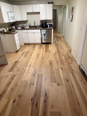 Engineered Hardwood - This kitchen floor remodeling project involves removing the existing flooring and installing new, durable materials to improve both functionality and appearance. The process begins with careful demolition and disposal of old flooring, followed by inspection and preparation of the subfloor to ensure it is clean, level, and structurally sound.
After preparation, a moisture barrier or underlayment is installed as needed to enhance durability and performance. The new flooring—such as tile, luxury vinyl plank, hardwood, or laminate—is then precisely measured, cut, and installed to ensure proper alignment and a seamless fit around cabinets, appliances, and doorways. Special attention is given to high-traffic areas and transitions to adjacent rooms.
Once installation is complete, trim pieces and transition strips are added for a polished finish. The project concludes with a detailed inspection and thorough cleanup. The remodeled kitchen floor provides improved durability, easier maintenance, and an updated, modern look that enhances the overall value and comfort of the home.