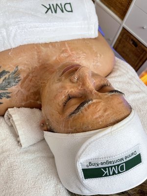 DMK Enzyme Therapy - DMK enzyme therapy restores skin to its peak condition.
DMK is the only company in the world to utilize the beneficial effects of transfer messenger enzymes. Enzymes are living substances that regulate health and work with certain minerals in the body to form a natural system of antioxidants that fight corrosive free radicals. Properly formulated, they can remove dead protein, toxins and other effluvia from the epidermis using a process called ‘reverse osmosis’.
Where some cosmetic facial treatments may only act on the surface of the skin, DMK Enzyme Treatments work with the skin. The enzymes aim to strengthen the structural integrity of the skin to create a healthy environment for cells to live and thrive in. Enzyme Therapy exercises facial muscles and works to leave the skin feeling firm.
DMK Muscle Banding is a technique used to lift, tone, and tighten the skin. It works by causing the muscles to contract, reinvigorating circulation, increasing amino acids, and restoring optimal function. It rebuilds a stronger healthier better functioning skin, stimulating collagen and elastin and strengthens the matrix, giving skin back its bounce. Even before signs of ageing become apparent, this treatment works to prevent the decline in the functioning of your skin that causes ageing. Whether you want to maintain or regain a tight youthful appearance, DMK Muscle Banding is like the army that comes in and stops the decline that causes skin to age. This can be added to the regular enzyme treatment after we’ve worked up to it! DMK Enzyme Therapy - DMK enzyme therapy restores skin to its peak condition.
DMK is the only company in the world to utilize the beneficial effects of transfer messenger enzymes. Enzymes are living substances that regulate health and work with certain minerals in the body to form a natural system of antioxidants that fight corrosive free radicals. Properly formulated, they can remove dead protein, toxins and other effluvia from the epidermis using a process called ‘reverse osmosis’.
Where some cosmetic facial treatments may only act on the surface of the skin, DMK Enzyme Treatments work with the skin. The enzymes aim to strengthen the structural integrity of the skin to create a healthy environment for cells to live and thrive in. Enzyme Therapy exercises facial muscles and works to leave the skin feeling firm.
DMK Muscle Banding is a technique used to lift, tone, and tighten the skin. It works by causing the muscles to contract, reinvigorating circulation, increasing amino acids, and restoring optimal function. It rebuilds a stronger healthier better functioning skin, stimulating collagen and elastin and strengthens the matrix, giving skin back its bounce. Even before signs of ageing become apparent, this treatment works to prevent the decline in the functioning of your skin that causes ageing. Whether you want to maintain or regain a tight youthful appearance, DMK Muscle Banding is like the army that comes in and stops the decline that causes skin to age. This can be added to the regular enzyme treatment after we’ve worked up to it!
