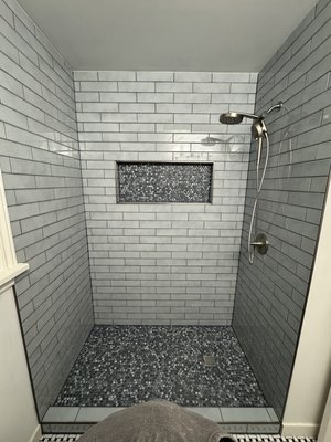 Tub to shower conversion with modern blue subway tile. - This remodel was done on a 1940s home with a cast-iron tub and outdated tile surround. We completed a tub to shower conversion with a center drain, large soap niche, modern blue subway tile with penny mosaic tile for accent. For flooring, we installed a classic Baskett weave mosaic tile. We also updated all plumbing and roughed in for a modern floating vanity.