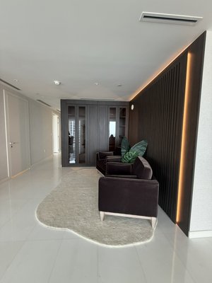 Sleek slat wall with lights and storage cabinet - This modern luxury living space features a dramatic floor-to-ceiling backlit vertical slat wall that serves as the centerpiece, casting a warm, elegant glow throughout the room. Two plush velvet armchairs sit on a soft, organically shaped rug, creating an inviting seating area with stunning ocean views visible through the glass doors. Custom dark wood built-ins with sleek lighting complete the sophisticated and serene design.
Clean lines, premium finishes, and thoughtful details make this a standout contemporary interior. Sleek slat wall with lights and storage cabinet - This modern luxury living space features a dramatic floor-to-ceiling backlit vertical slat wall that serves as the centerpiece, casting a warm, elegant glow throughout the room. Two plush velvet armchairs sit on a soft, organically shaped rug, creating an inviting seating area with stunning ocean views visible through the glass doors. Custom dark wood built-ins with sleek lighting complete the sophisticated and serene design.
Clean lines, premium finishes, and thoughtful details make this a standout contemporary interior.